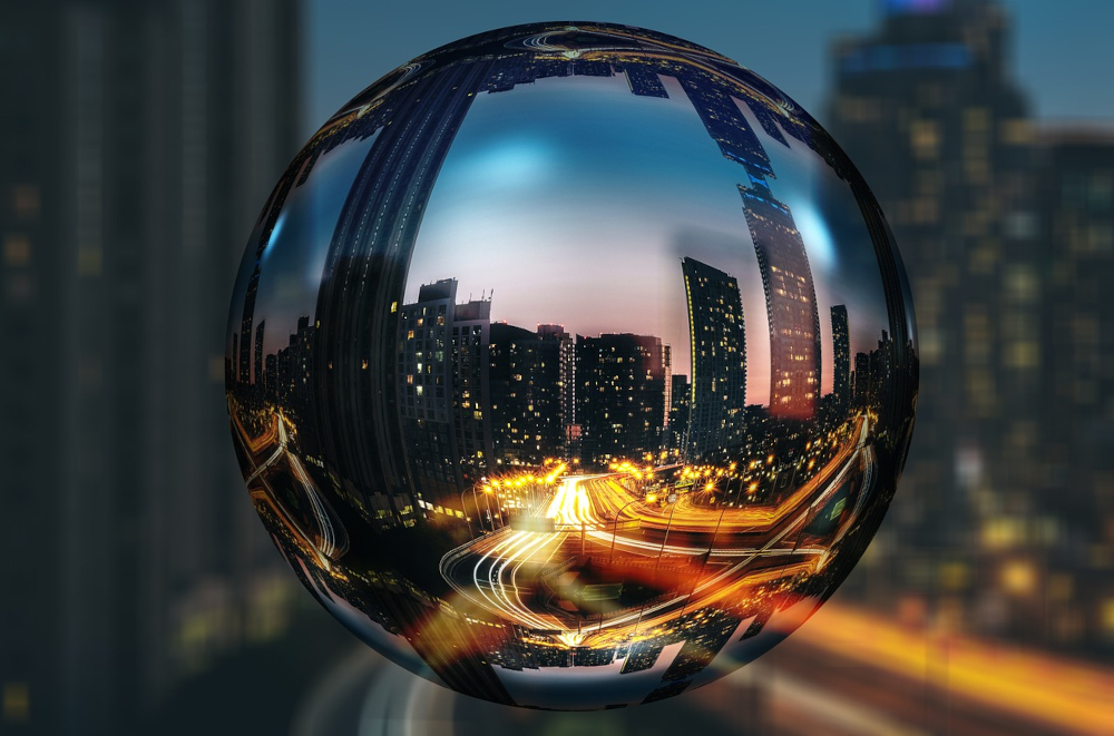 a crystal ball is seen above downtown Toronto, the streets and cars and buildings are seen reflected in its surface. 