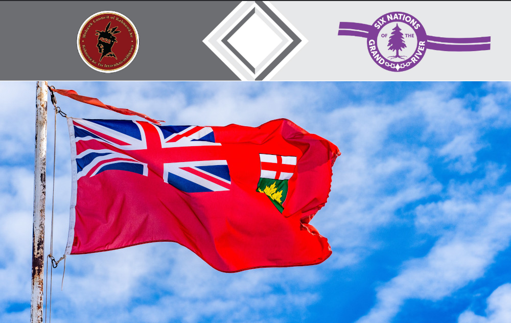 The Ontario flag is seen against a blue sky. Above it is an inset with the logos of the Mohawk Council of Kahnawake & the Six Nations of the Grand River, the two groups that have partnered to fight for their right to self-regulate their iGaming platforms.