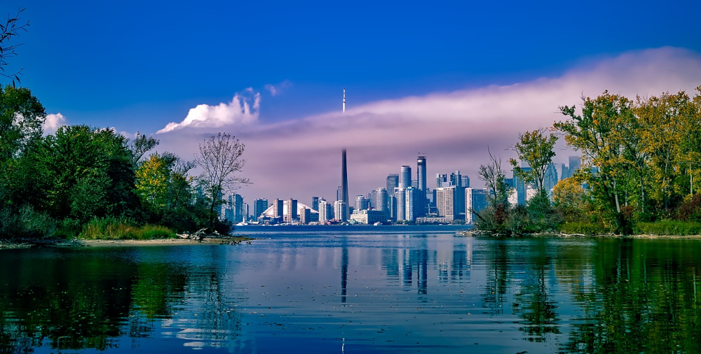 Toronto skyline is seen against blue sky. CN Tower and skyscrapers rise up from the shore of Lake Ontario, clouded by dense fog. Ontario, Canada's biggest province, launched its new regulated iGaming market on April 4.