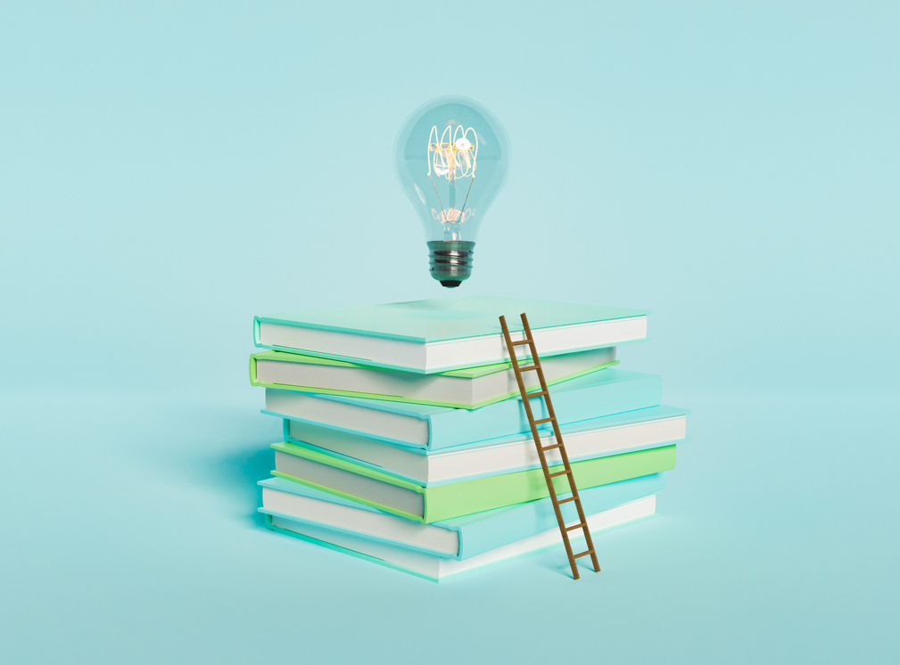 a stack of blue and green books on a blue background with a small ladder up the side of the books. above is a lightbulb. New Responsible Gambling Tools Research Paper: Key Highlights & Takeaways